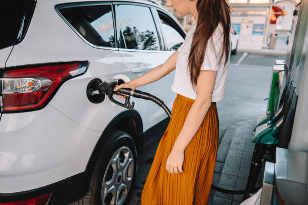 istock Young woman refueling her car at gas station 1414488607