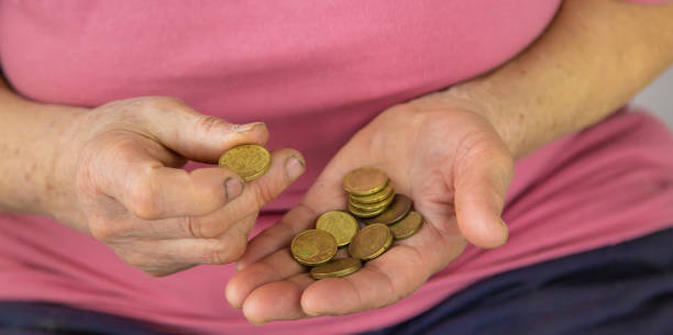 istock An old woman counts small money. Selective focus. 1414489510