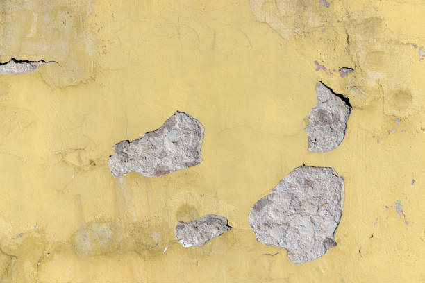 istock Damaged yellow plaster of a concrete wall 1414489583