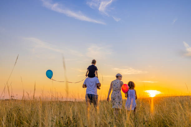 istock Family spending leisure time while exploring amidst grassy field during sunset 1414491056