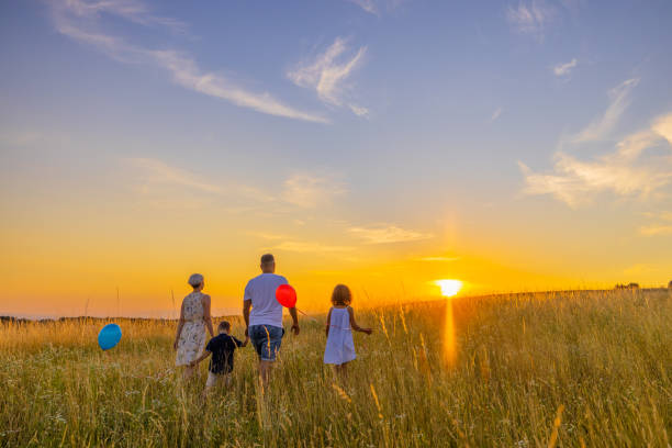 istock Family walking together while exploring in meadow against sky 1414491485