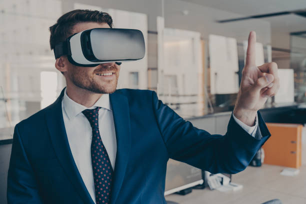 istock Young financier wearing VR headset glasses, while standing in his office 1414491970