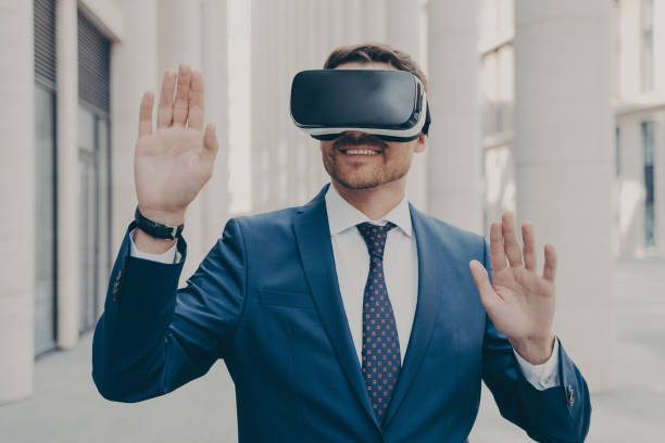 istock Businessman in suit trying out and experiencing virtual reality using mobile VR headset outdoors 1414492517