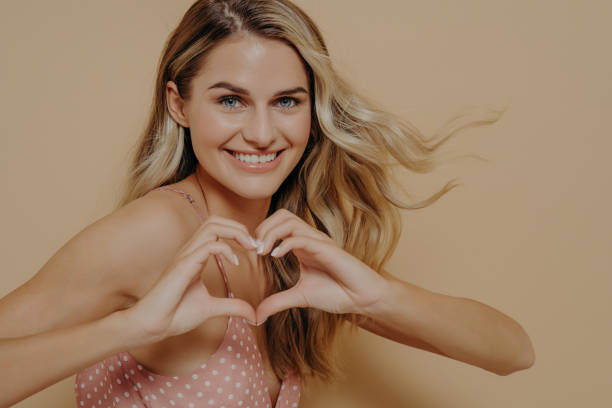 istock Blonde woman making heart shape with her hands 1414493336
