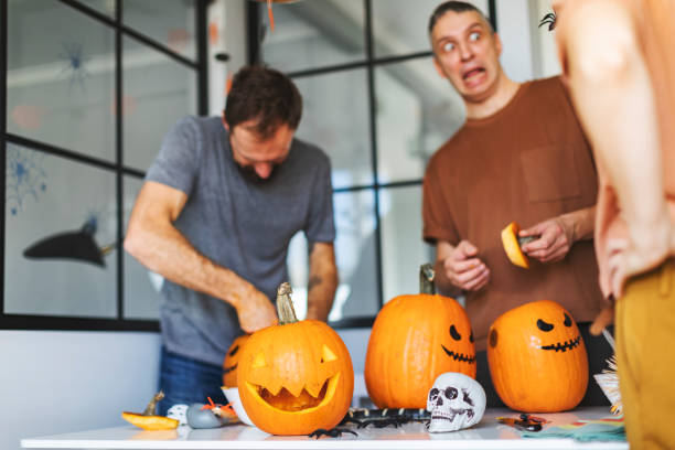 amigos celebrando halloween en casa y preparando calabazas - halloween pumpkin party carving fotografías e imágenes de stock