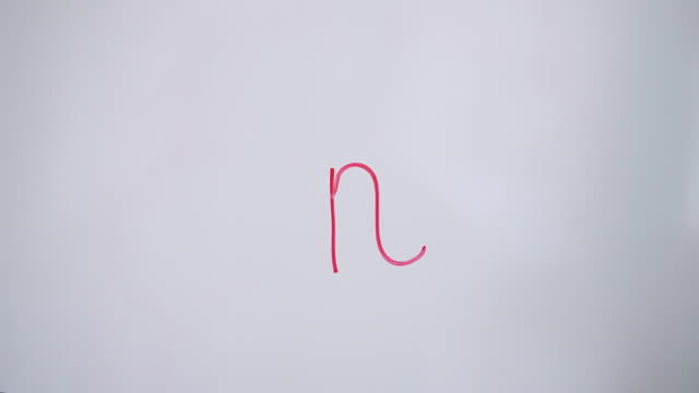 Hand Writing Lowercase Letter n On White Board With Red Marker