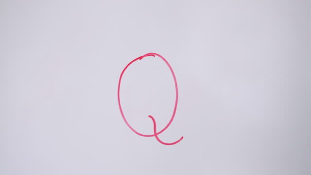Hand Writing Capital Letter Q On White Board With Red Marker