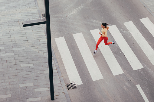 Above shot of a Caucasian woman running outdoors wearing sportswear.