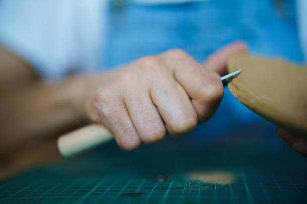 Close up to human hand holding a ceramic piece