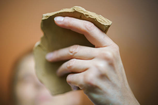 Close up to human hand holding a ceramic piece