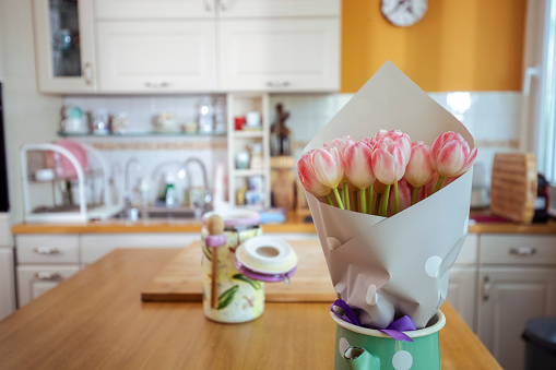 A close-up of a bouquet of flowers standing in a vase on the living room table.