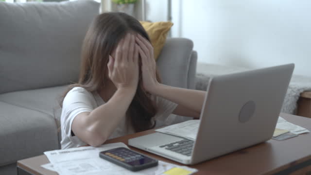 Asian woman is stressed and worried when she sees her bill.