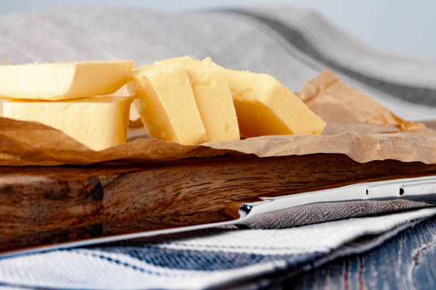 Cut butter on plate with blue towel on kitchen table Cut butter on plate with blue towel on kitchen table, close up. margarine stock pictures, royalty-free photos & images