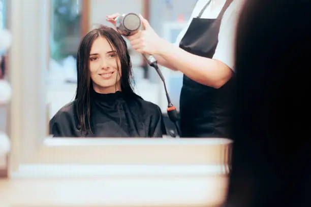 Happy client ready to have her hair styled at the salon