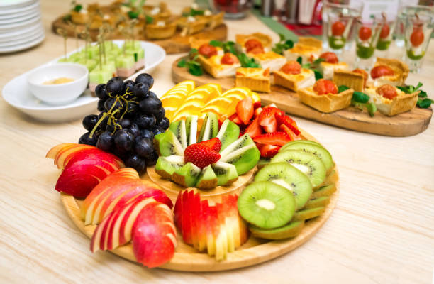 An appetizer of sliced fresh ripe fruit on a wooden round tray stock photo