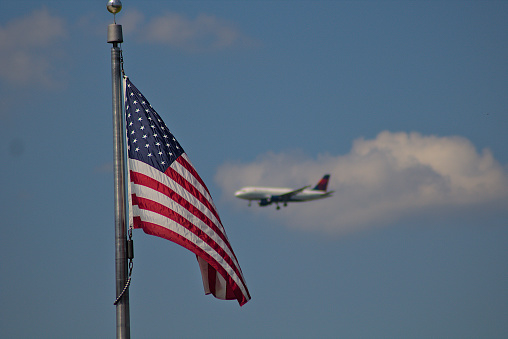plane ready to land but behind the American flag