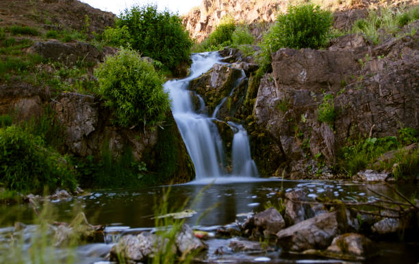 istock Waterfall and stream and lots of green trees and shrubs. 1414542524