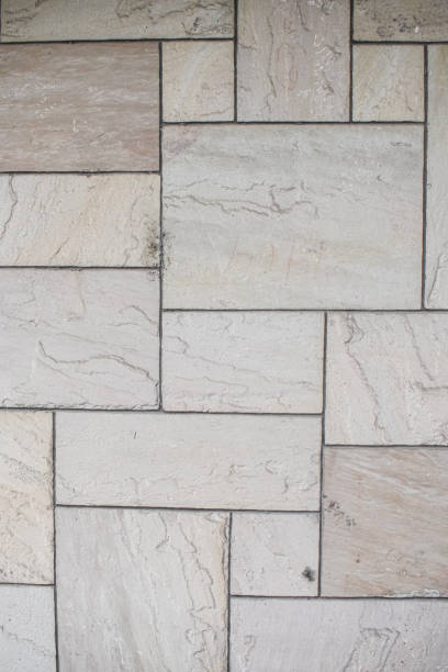 A picture of a beautiful and elegant wall made of concret, with a pattern of rectangular stones.