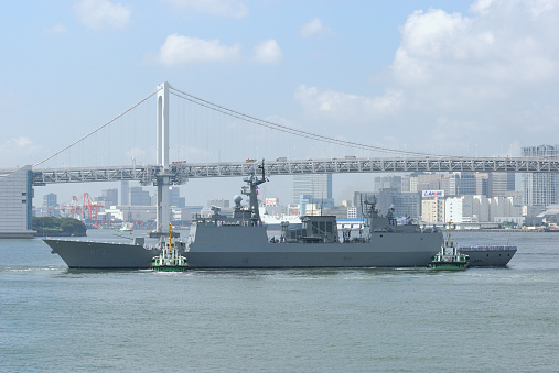 Industrial ships on the South China sea at port of Hong Kong. In the distance, the Stonecutters bridge.