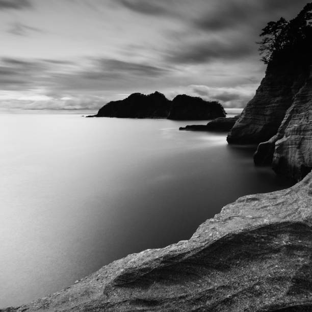 tiro dramático de longa exposição de ondas de rochas marinhas e céu nublado, prefeitura de shizuoka, japão - black and white landscape square long exposure - fotografias e filmes do acervo