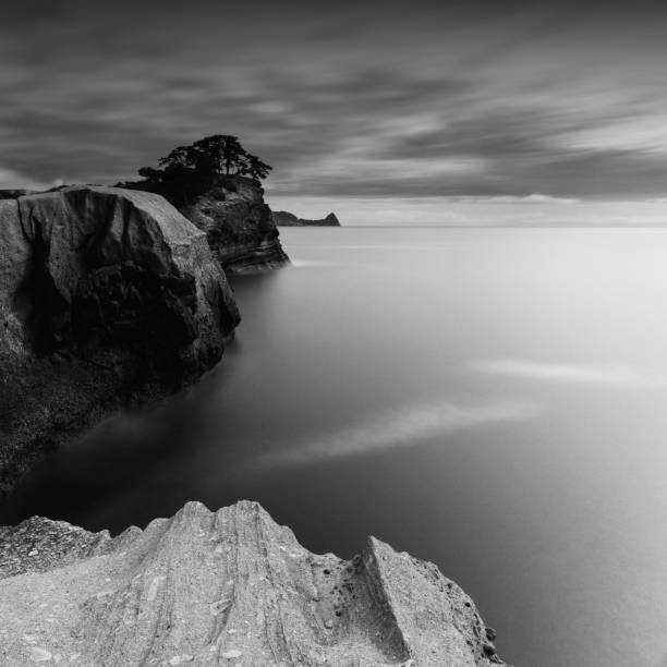 tiro dramático de longa exposição de ondas de rochas marinhas e céu nublado, prefeitura de shizuoka, japão - black and white landscape square long exposure - fotografias e filmes do acervo