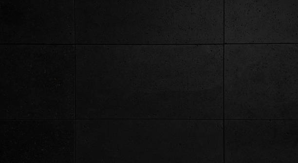istock close up dark black modern building stone wall tile, porous stone, granite texture background. exterior rusty and grungy stone wall use as background. matt wall tile with dry process installation. 1414563692