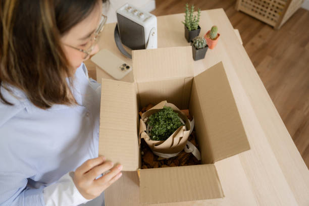 istock Cheerful Asian woman opening subscription box 1414564849