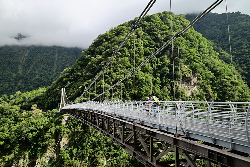Buluowan Terrace in Taroko National Park - Steep canyon spanned by a footbridge. A modern suspension footbridge spans this steep, densely forested gorge in a popular hiking area.