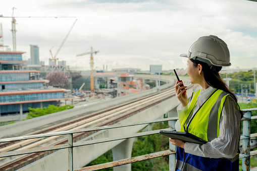 A female engineer inspecting work by making checklists through a tablet on a construction site.