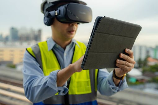 Engineers are discussing and monitoring the operations through virtual  reality technology on construction site.
