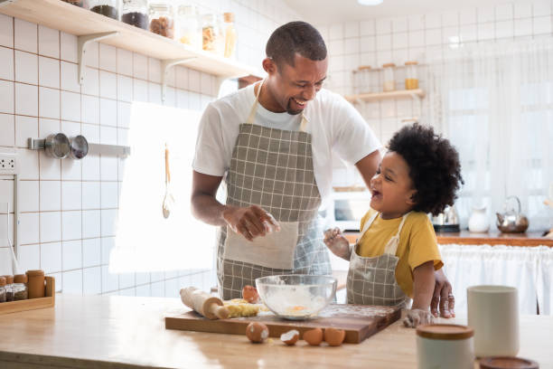 istock African Father and Afro boy laughing in kitchen 1414568791