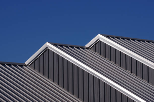 Cascading Roofs Partial view of cascading warehouse rooftops under blue sky corrugated iron stock pictures, royalty-free photos & images