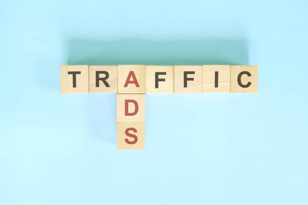istock Store traffic from ads advertising or advertisement in e-commerce concept. Wooden block crossword puzzle flat lay in blue background. 1414572638