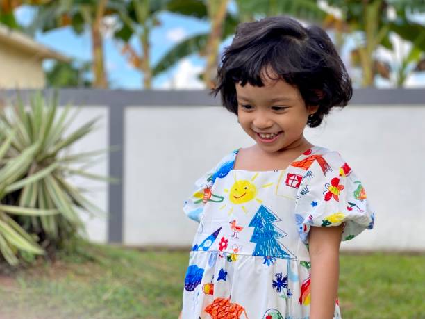 istock Cute kid standing smiling playing in the garden 1414576403