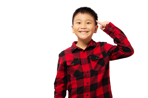 Happy kid with finger pointing head with smile, wearing red shirt isolated on white background