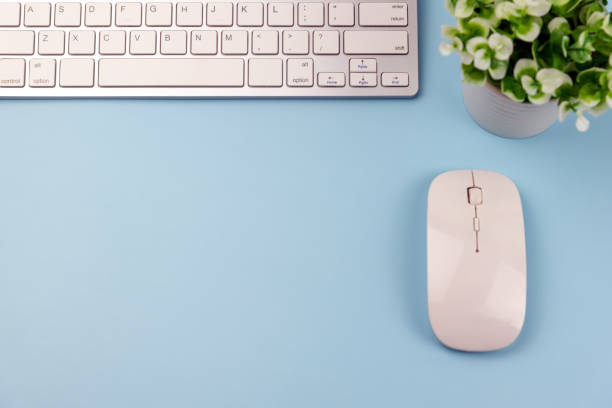 istock Computer keyboard and mouse on top of blue background desk 1414583335
