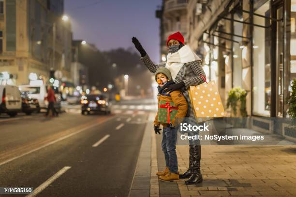 Mother and son calling a cab after Christmas shopping