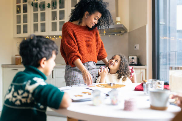 istock Mother making Christmas gingerbread cookies with kids 1414586367