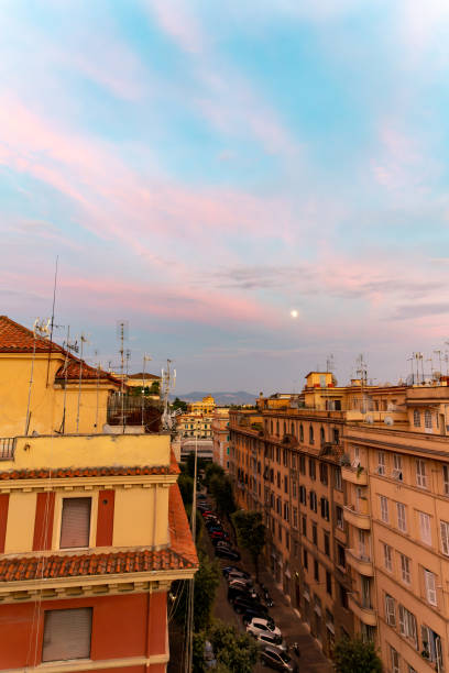 sunset from the rooftop of a residential apartment building in rome, italy - color image light pink dramatic sky imagens e fotografias de stock