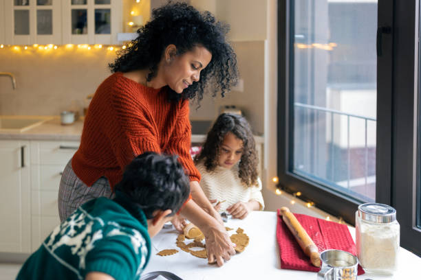 istock Mother making Christmas gingerbread cookies with kids 1414586531