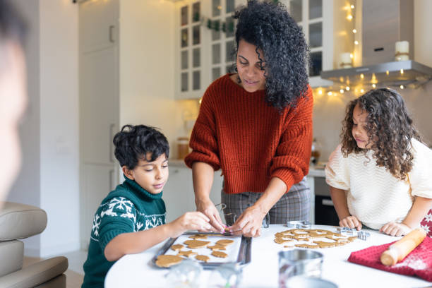 istock Mother making Christmas gingerbread cookies with kids 1414586532