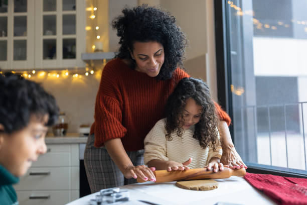madre haciendo galletas navideñas de jengibre con niños - christmas child cookie table fotografías e imágenes de stock