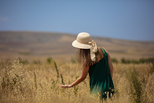 Green dresses Blonde girl in oat field