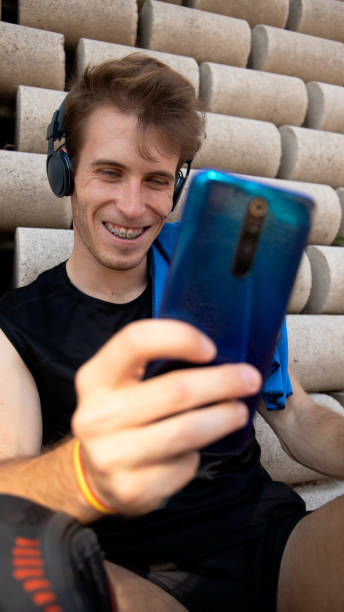 istock young man with brackets interacting with the mobile 1414591335