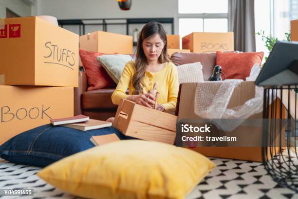 Happiness Young Adult Asian Female Woman Packing Things Into Boxes Prepare Moving From Old Place To New Home With Cheerful And Happinesshome Moving House Booming Ideas Concept Stock Photo - Download Image Now
