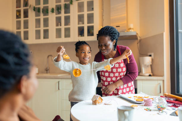 Mother making Christmas gingerbread cookies with daughter Mother making Christmas gingerbread cookies and sustainable Christmas tree decoration with daughter. It's a Christmas time. multi generation family christmas stock pictures, royalty-free photos & images