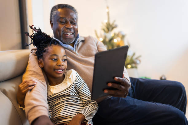 großvater und enkelin mit videoanruf - grandparent family reading inside of stock-fotos und bilder