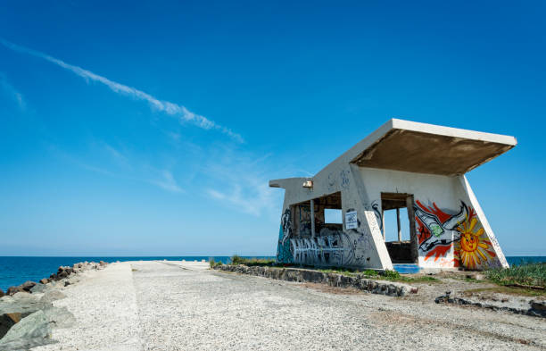 Stone quay on Black Sea shore in Pomorie with building with graffiti on it Pomorie, Bulgaria - May 11, 2022: Stone quay on Black Sea shore in Pomorie with building with graffiti on it. Bulgaria, Europe. pomorie stock pictures, royalty-free photos & images