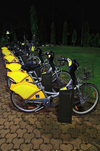 Bikes parked at night at one of the CityCycle sharebike public network 150 docking stations in the City Botanic Gardens ready for residents and visitors to swap them. Brisbane-Queensland-Australia.