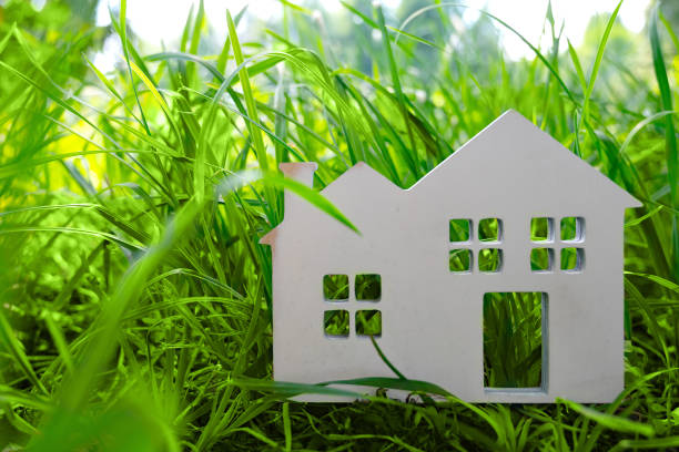 istock Little toy model house in large grass meadow field. 1414595628